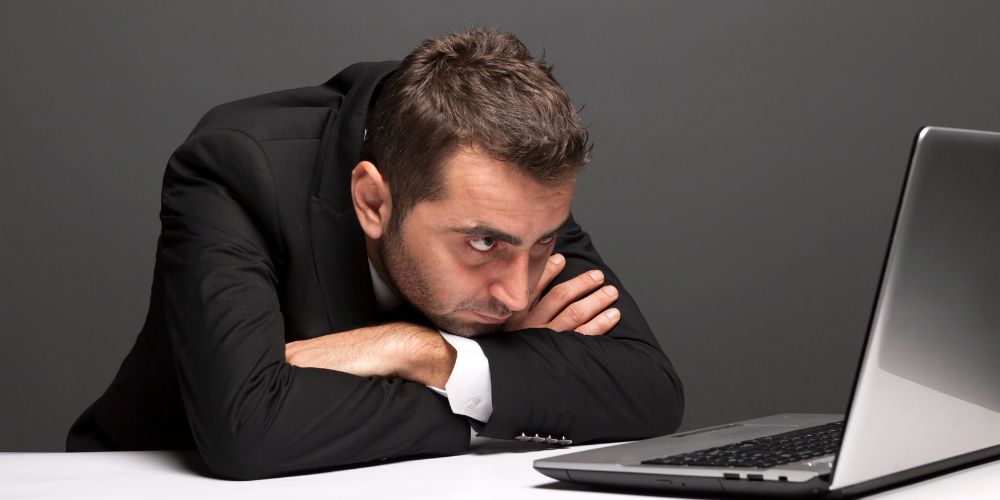 Man looking at his laptop and all his overbooked work