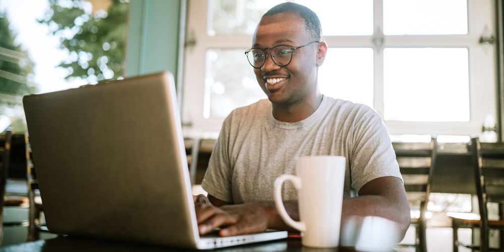 A man using CorelDraw on his laptop.