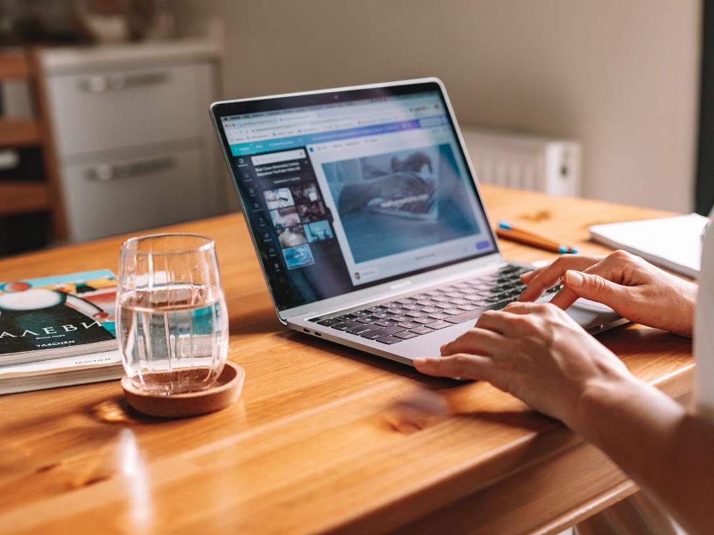 woman sitting at a desk typing on a laptop