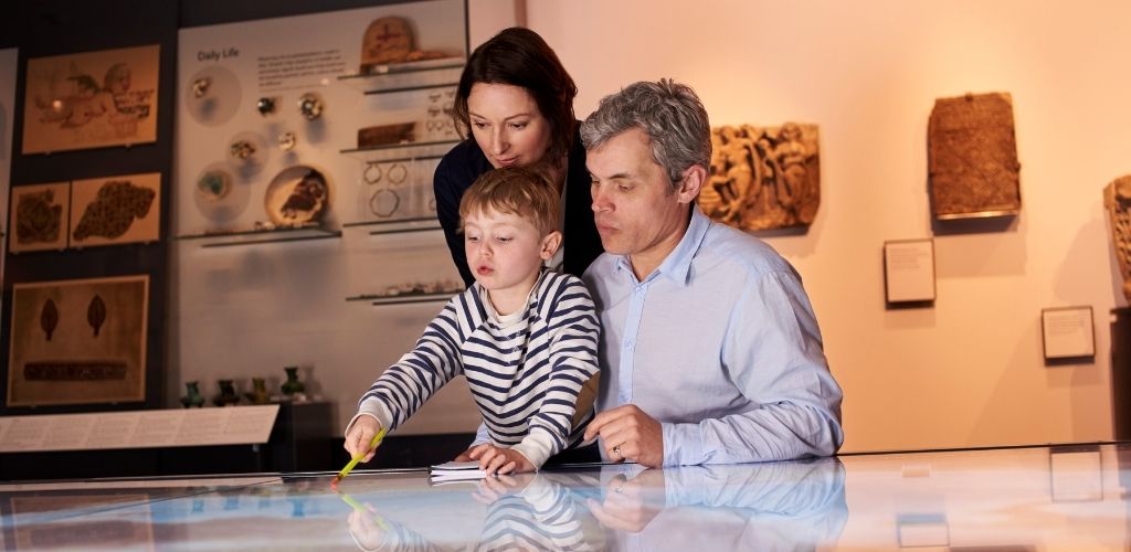 A mother and father joining their son in a museum
