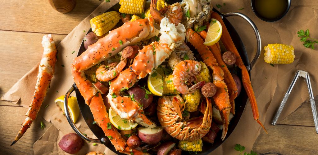 Seafoods composed of shrimps and crabs with corn, herbs and lemons