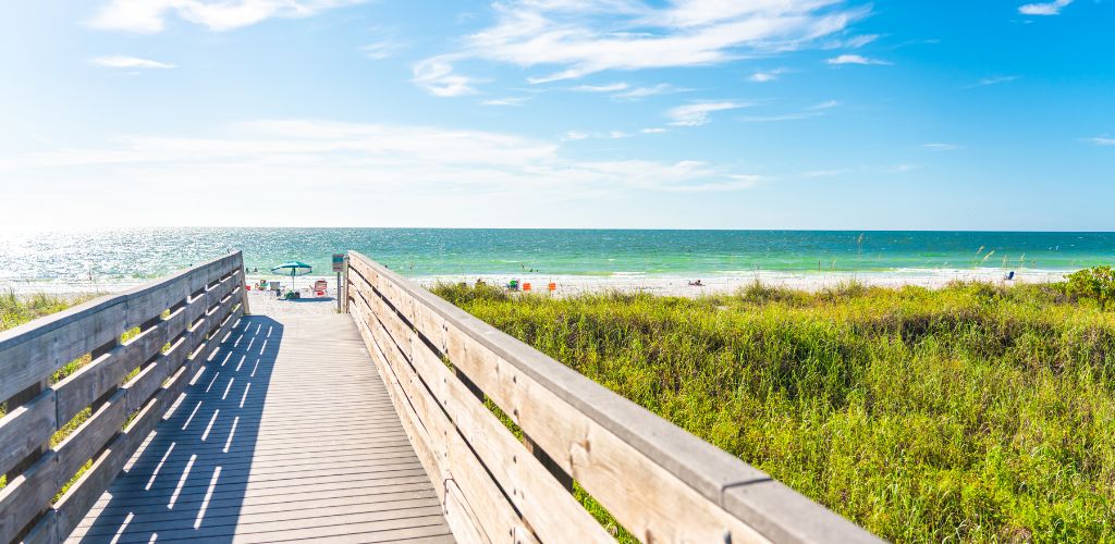 Indian Rocks Beach - A sunny day with ocean in the background and wooden alley