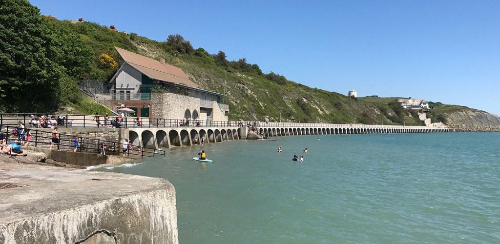 Sunny Sands with tourists, a long bridge and an old house made of bricks