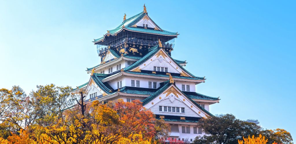 osaka castle with autumn foliage and blue sky