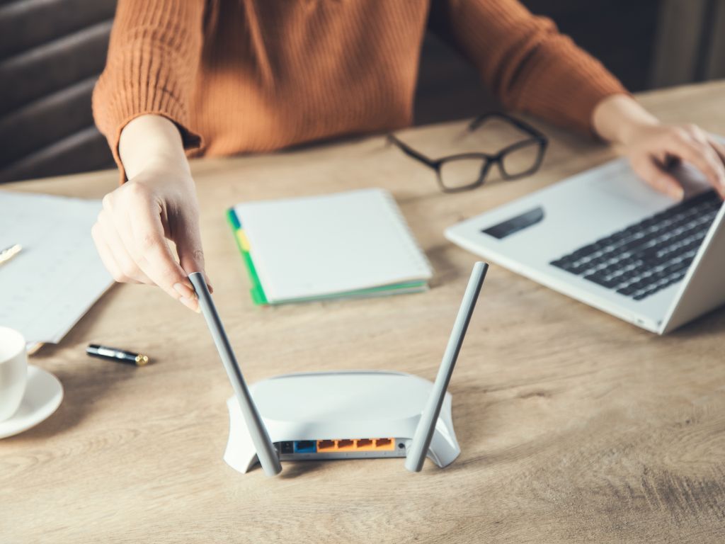 travel router on a desk with a notebook and laptop