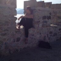 Nicola Curtis on an old fort wall looking out at a beautiful view