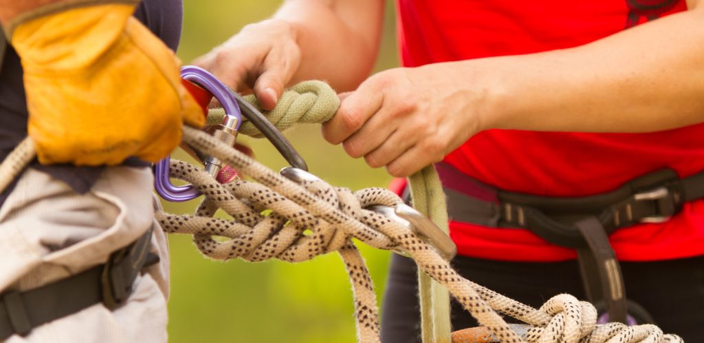 A two man preparing a safety harness.