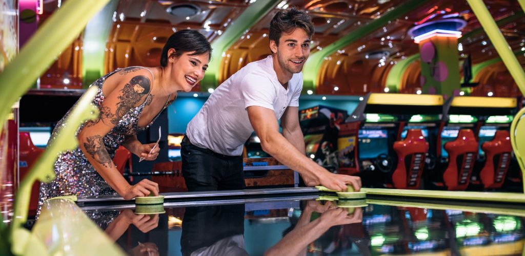 Couple Enjoying a Game of Air Hockey at a Gaming Arcade