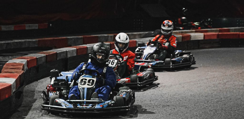 Three men driving karts on the racetrack.