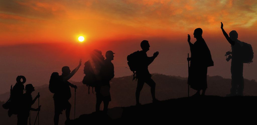 A group of mountaineers over the mountain at sunset. 