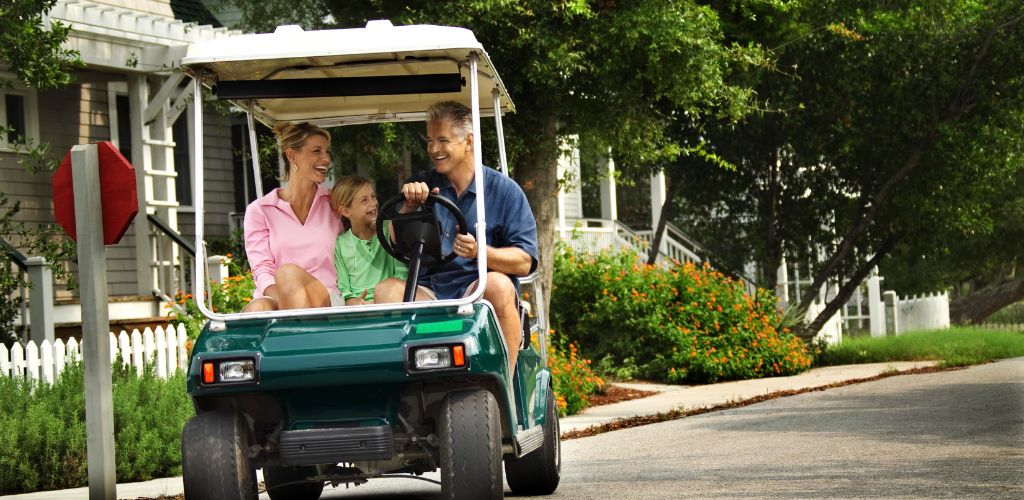 Family in a golf cart on the street. 