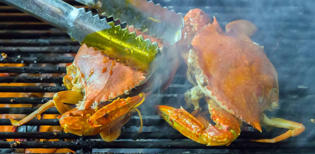 Crab frill with flames closeup of delicious grilled seafood. 