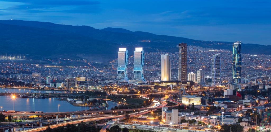 View of Izmir Turley from the sea in the afternoon, with city lights, buildings, and highways. 