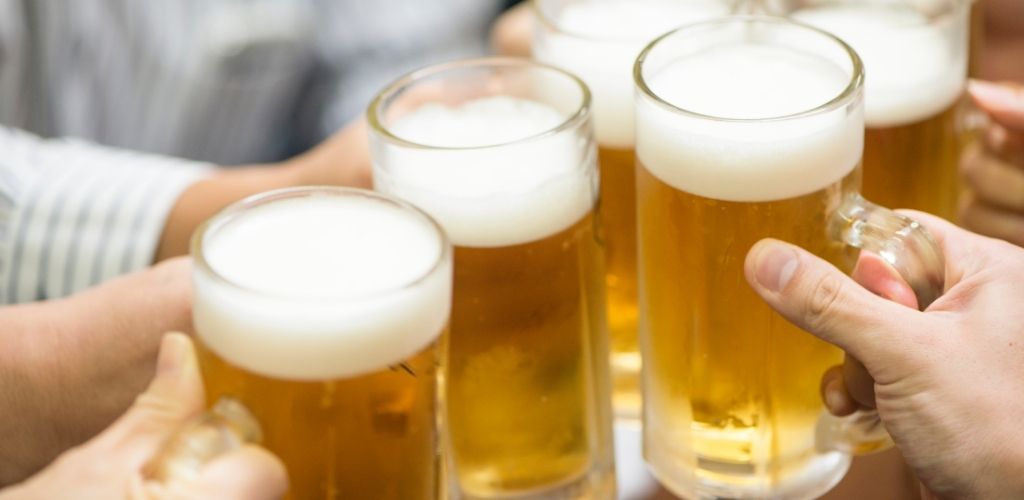 group of people toasting a glass of beer.
