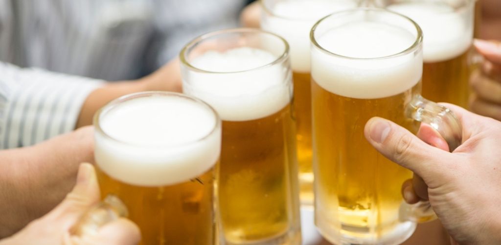 group of people toasting a glass of beer. 