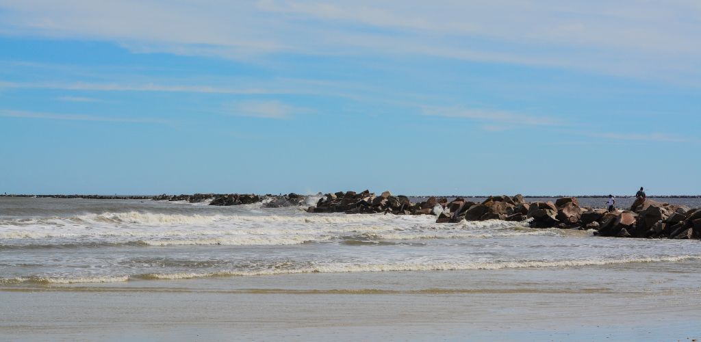 The sea water was divided by a wavy waterfront and a large number of large stones. 