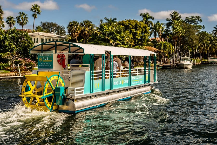 Paddle Pub tourist cruise on the lake, with lush trees on the side lake.