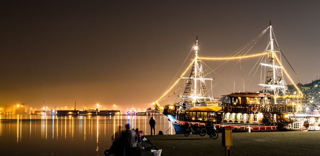 At night, an old pirate ship rests on the pier. 