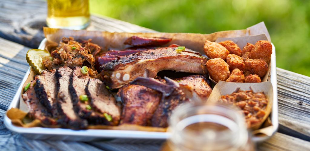 Tray of Smoked Meats  Bbq Style outside wooden table on Sunny Summer Day