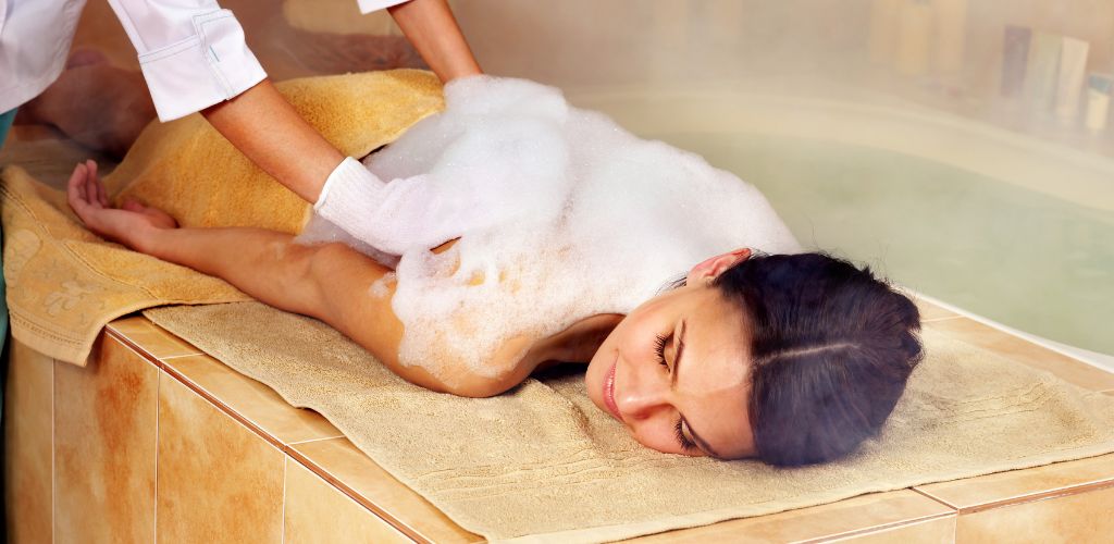 Woman in hammam or Turkish bath. steam in bathroom.