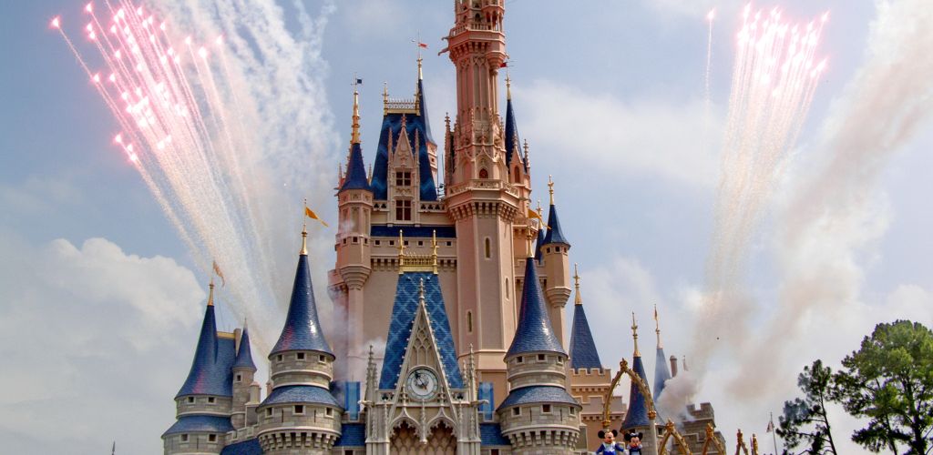 Fireworks in sky over fairy tale castle in amusement park. 