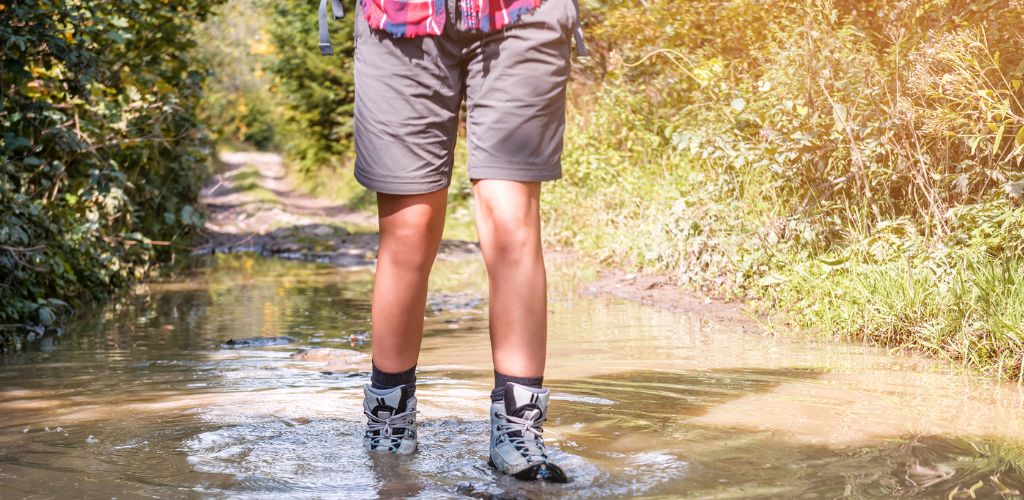 A man walking on a wet trail