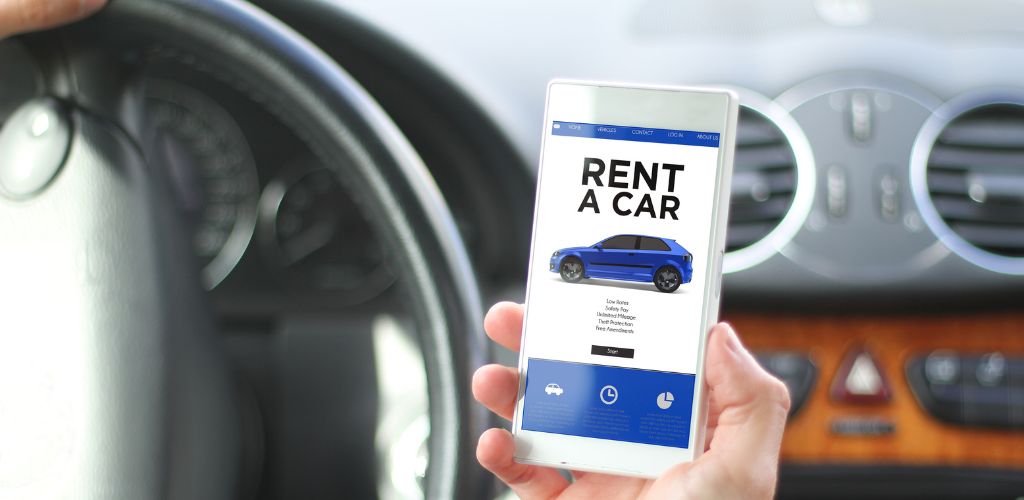 Rent concept drover holding smartphone with rent a car website on screen. 