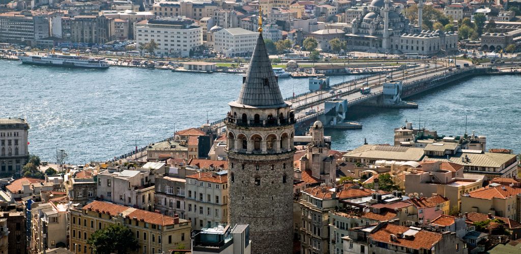 Aerial vie of Galata Tower in Istanbul surrounded by city and a view of bridge. 