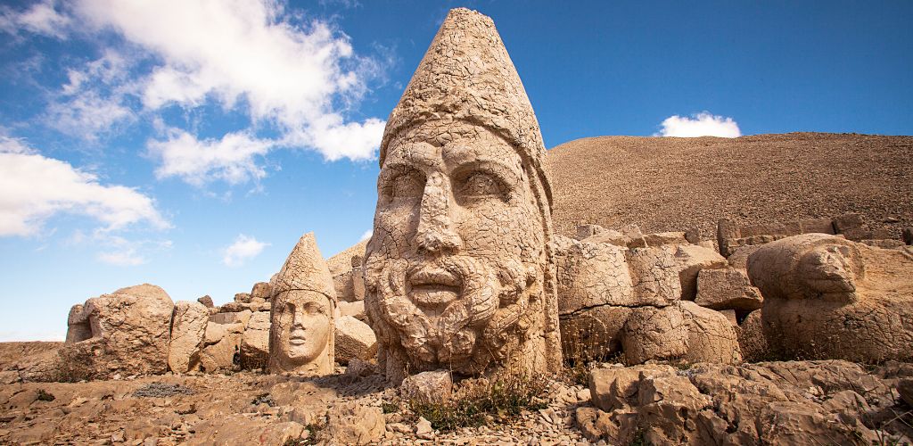 An old statue of a big head on the top of the mountain. 