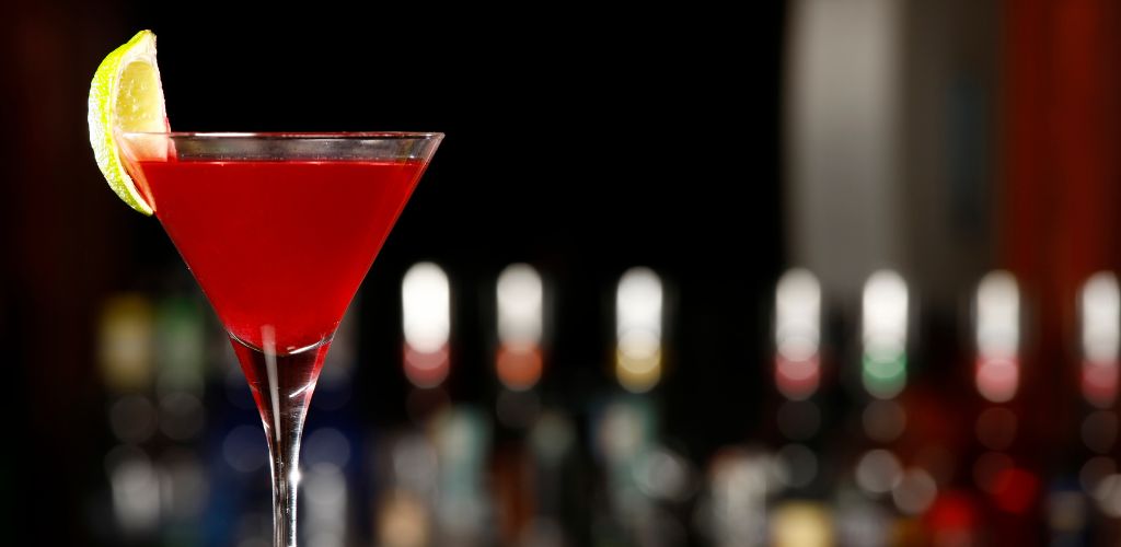 Cosmopolitan drink over black bar. 