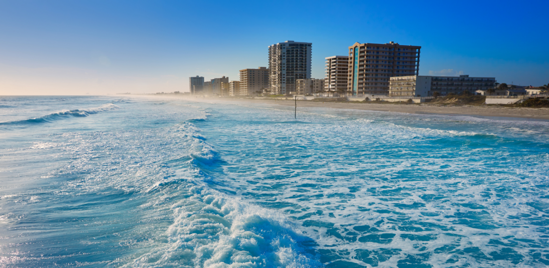 Shore Buildings and wavy waterfront water at Daytona Waterfront in Florida.