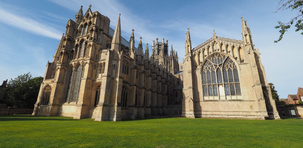 An old cathedral with beautiful, clean grass on the outside. 