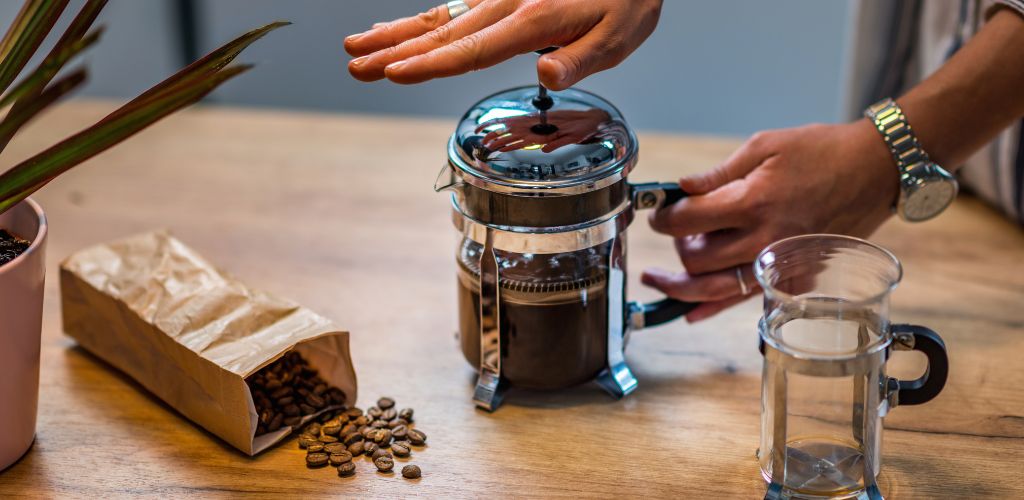 French press coffee and a small bag pf roasted coffee. 