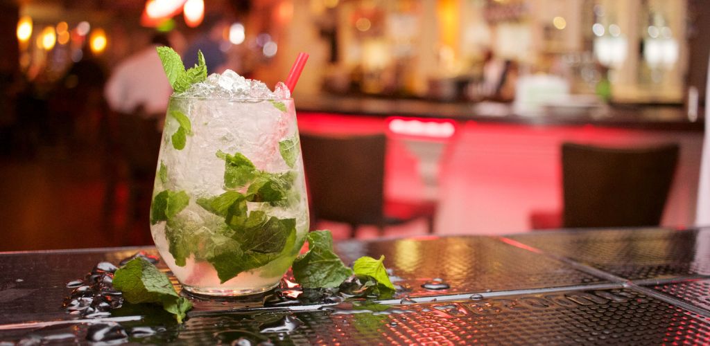 A refreshing Mojito Drink is served at a black table in the bar. 