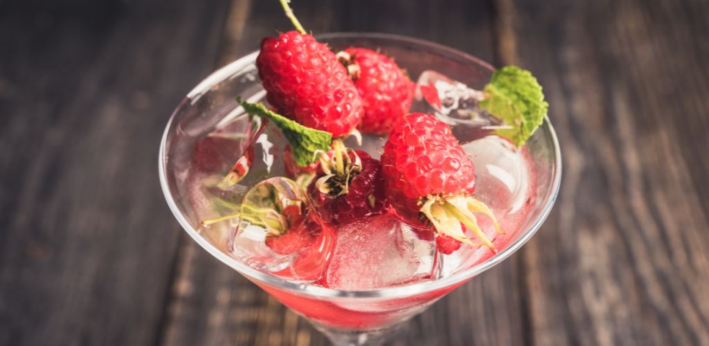 Raspberry martini cocktail on the wooden table. 