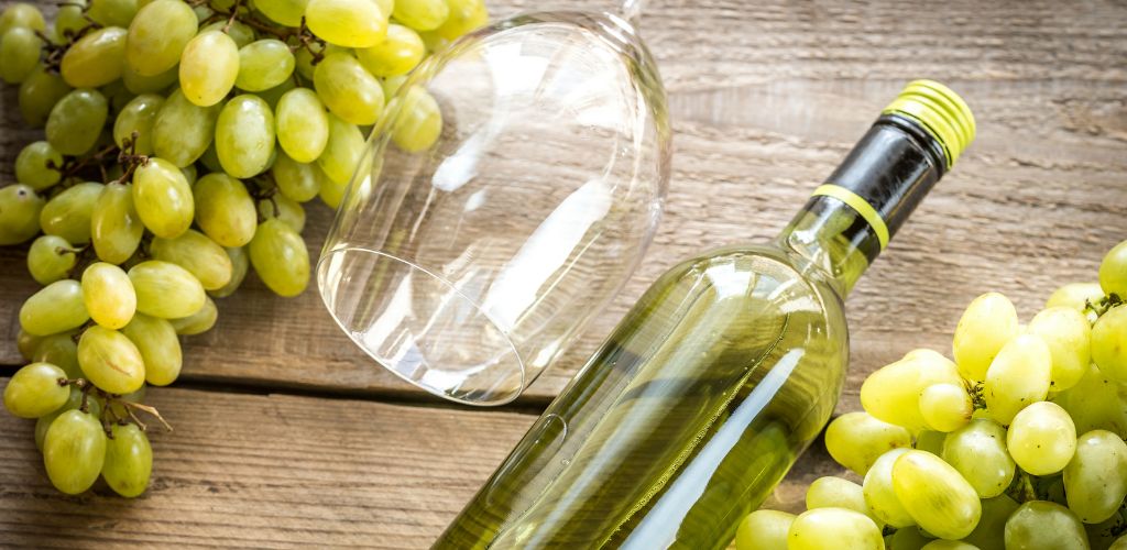 A bottle of white wine with Bunch of Grape