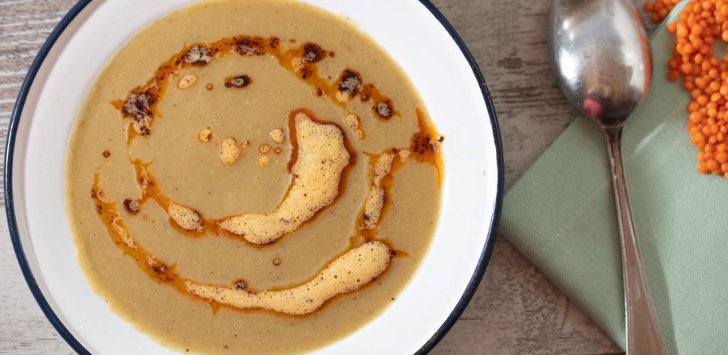 Turkish Lentil soup with fried butter sauce and spoon on the side.