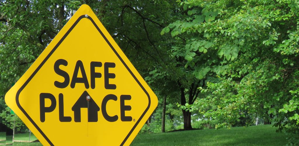 A Yellow Safe Place sign and a green forest in the background. 
