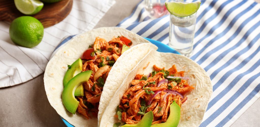 A plate of delicious tacos with tequila line chicken on the table. 