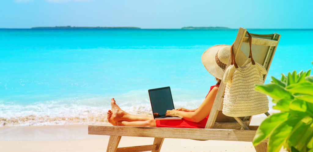 Young woman with laptop on beach